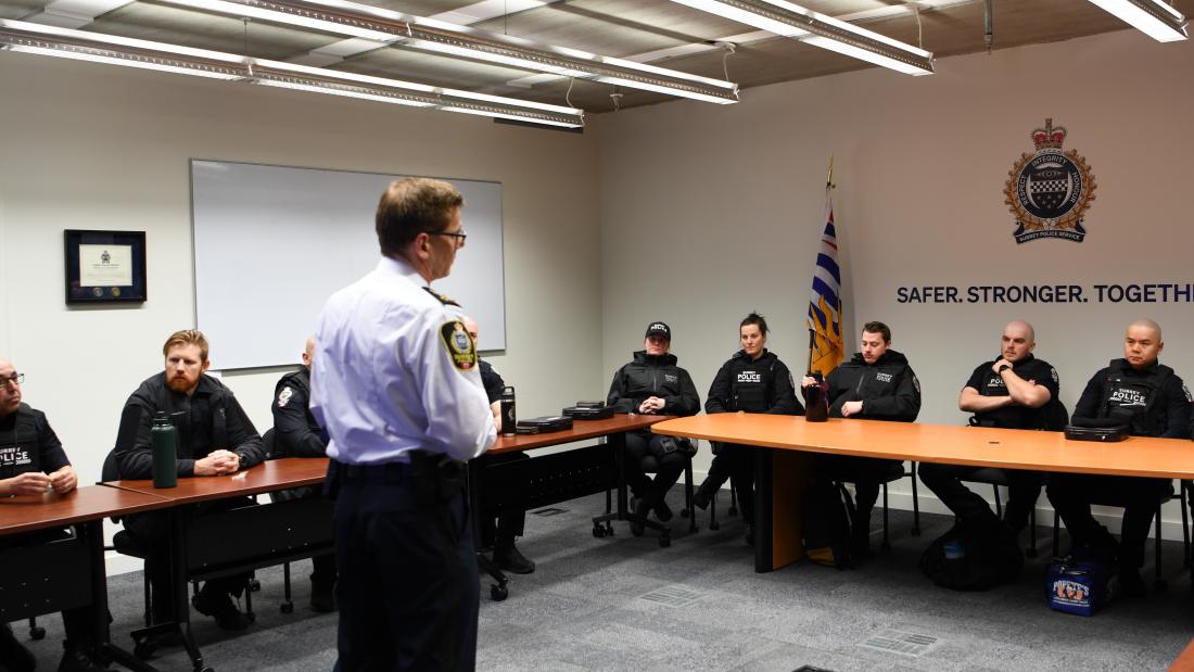 officers watch as Chief Constable gives speech before deployment