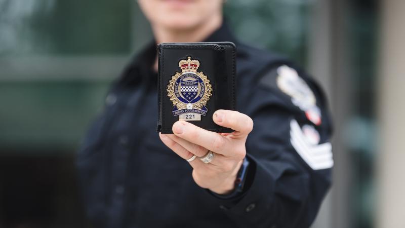 officer holds up badge 